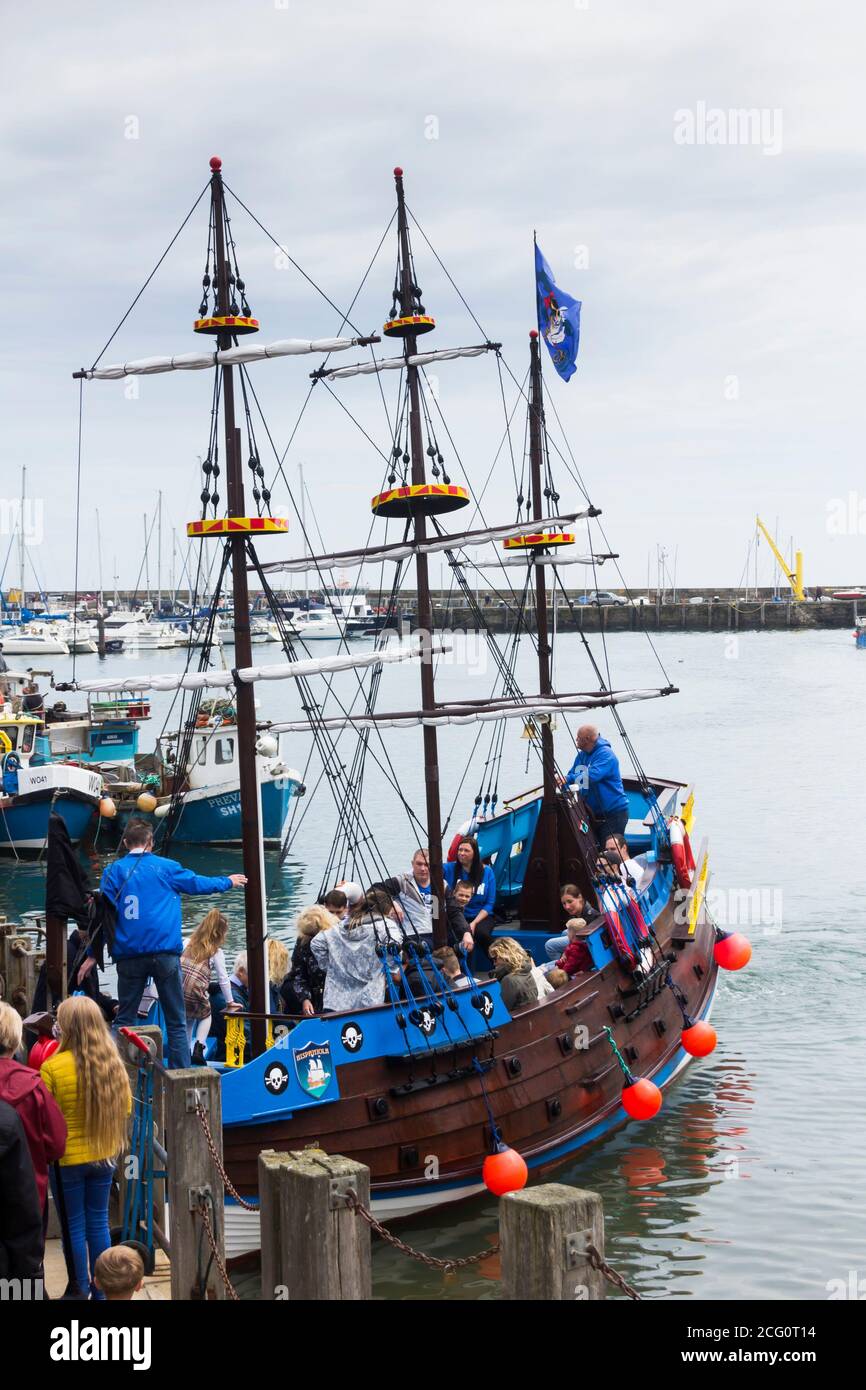 Passengers boarding Hispaniola in Scarborough harbour. The ship is a quarter size replica schooner carrying visitors on pleasure trips around the bay Stock Photo