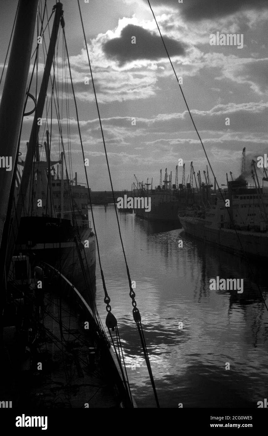 AJAXNETPHOTO. SEPT, 1963. SALFORD, MANCHESTER, ENGLAND. - SUNSET OVER THE DOCKS - VIEW FROM THE DECK OF A CARGO SHIP OF SALFORD DOCKS FILLED WITH SHIPPING. ICONIC LOCATION IN 1961 MOVIE A TASTE OF HONEY. PHOTO:JONATHAN EASTLAND/AJAX REF:M120639 091 Stock Photo