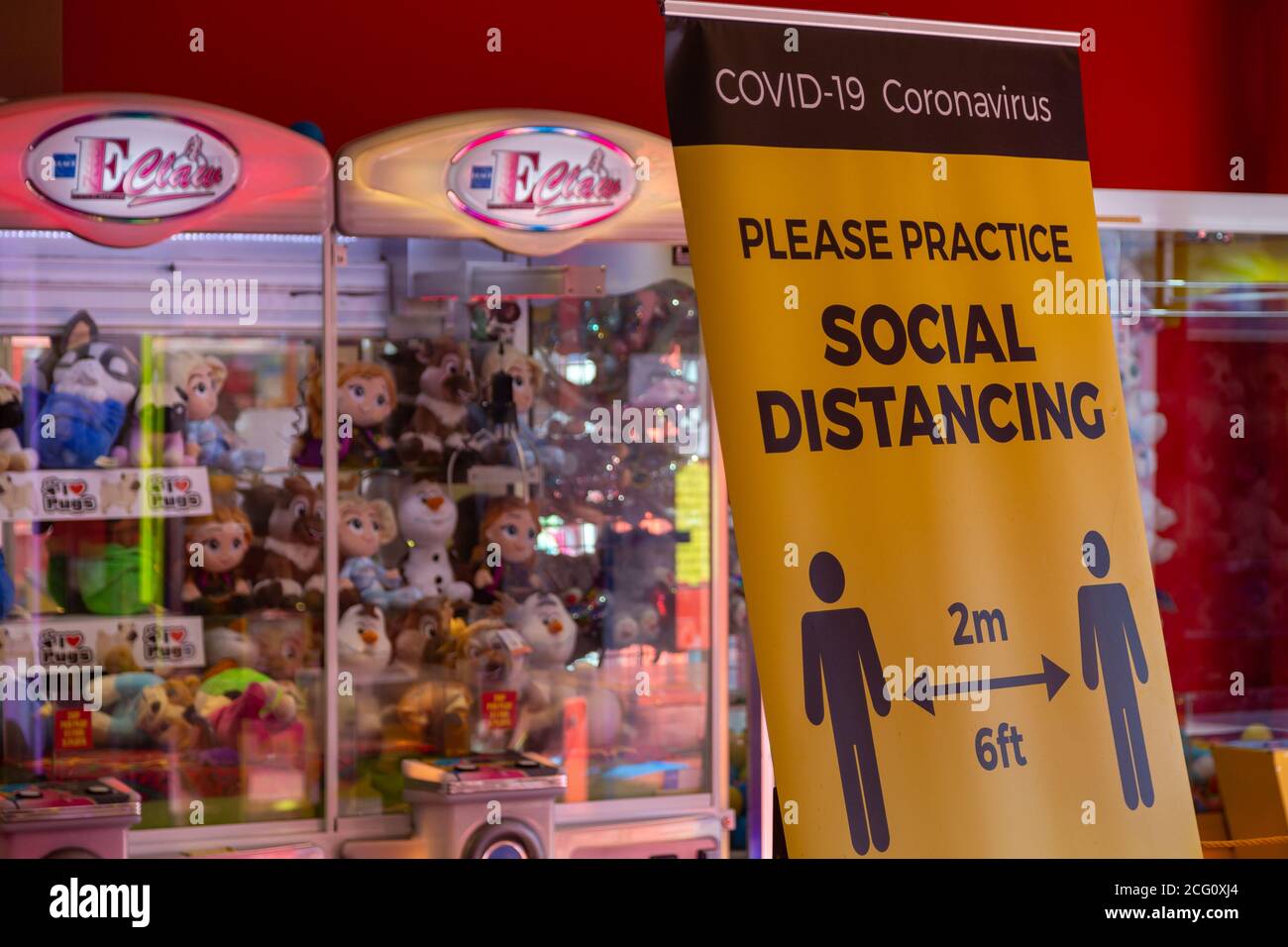 A social distancing sign inside an amusement arcade during the coronavirus Pandemic Stock Photo