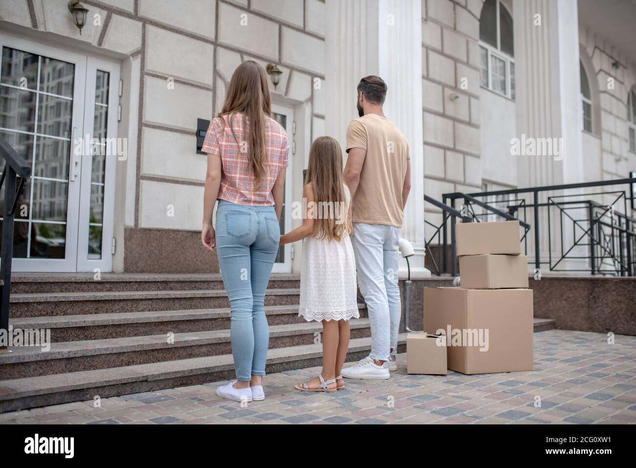 Young family standing near their new home Stock Photo - Alamy
