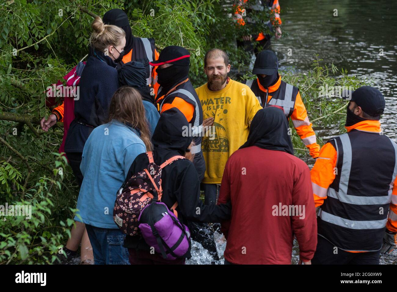 Denham, UK. 8th September, 2020. HS2 security guards try to prevent HS2 Rebellion activists from supporting a fellow activist who had climbed a tree in Denham Country Park in order to try to protect it from works for the HS2 high-speed rail link. Anti-HS2 activists continue to try to prevent or delay works on the controversial £106bn project for which the construction phase was announced on 4th September from a series of protection camps based along the route of the line between London and Birmingham. Credit: Mark Kerrison/Alamy Live News Stock Photo