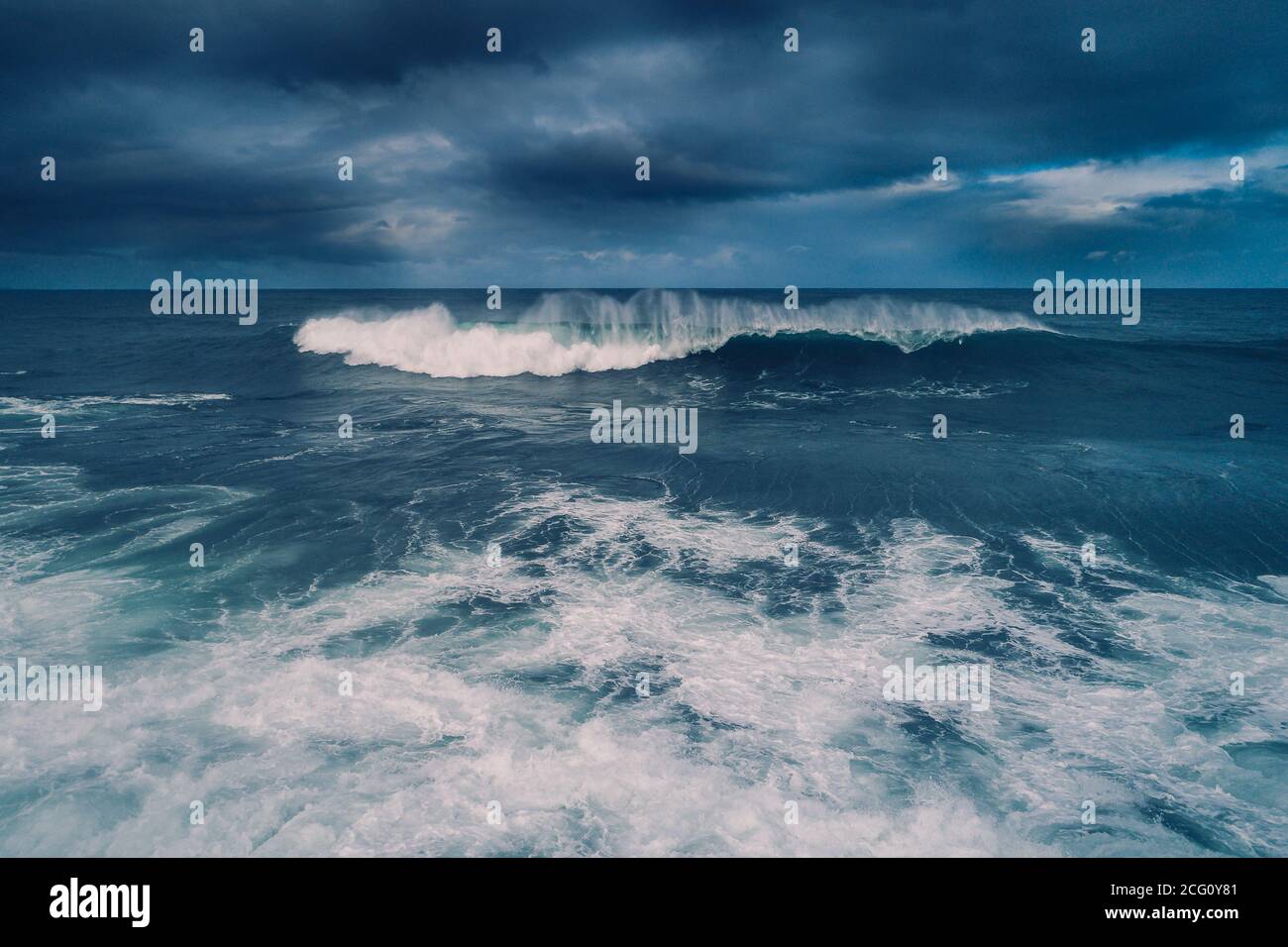 Moody weather conditions with heavy wave crashing along coastline Stock Photo