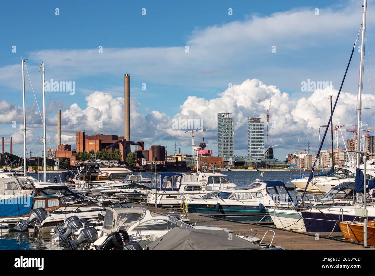 Moored boats at Tervasaari pier, Hanasaari coal power plant and Kalasatama high-rise buildings in the background, in Helsinki, Finland Stock Photo
