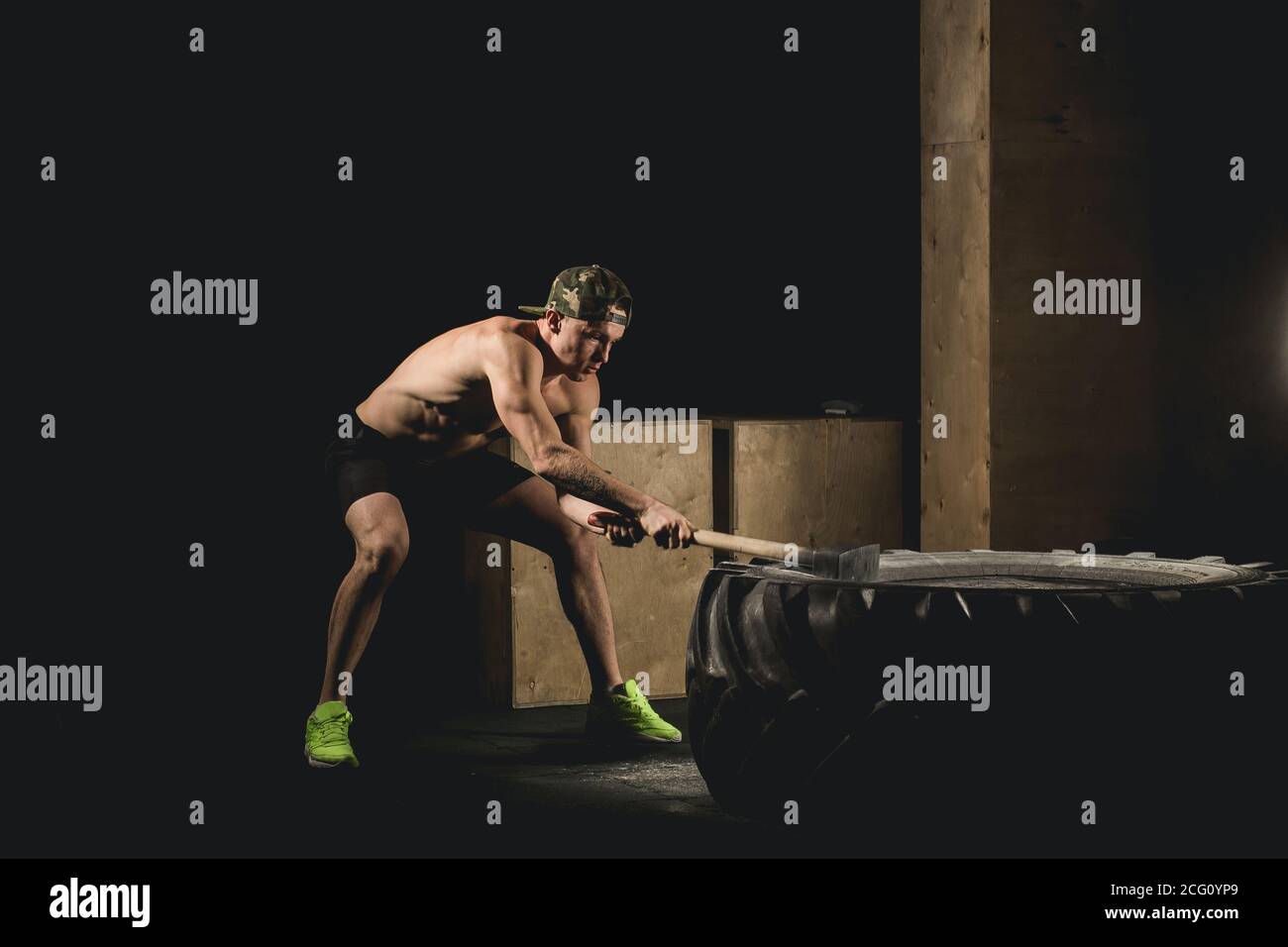 Athletic Man Hits Tire Workout At Gym With Hammer And Tractor Tire