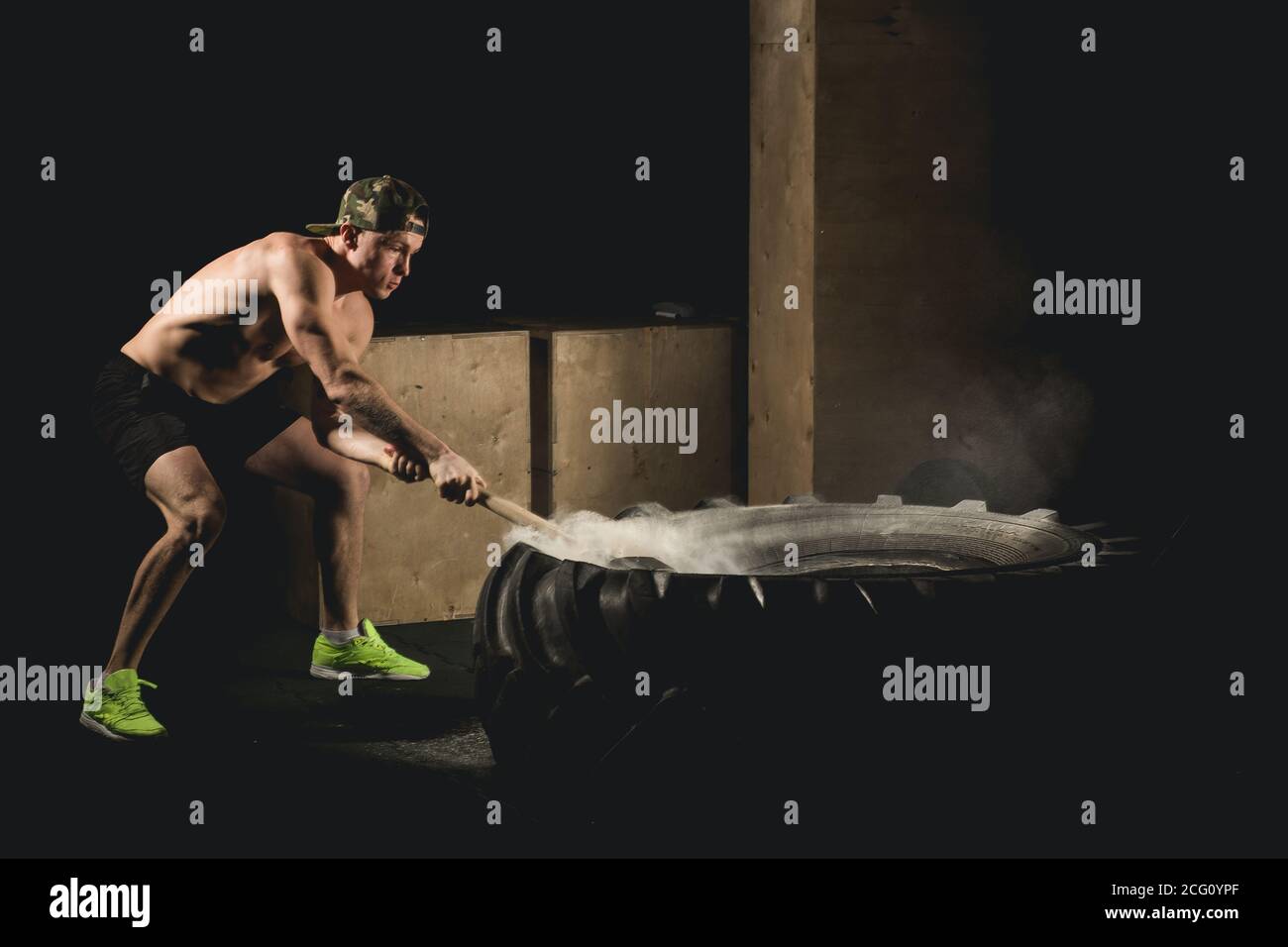 Athletic Man Hits Tire Workout At Gym With Hammer And Tractor Tire