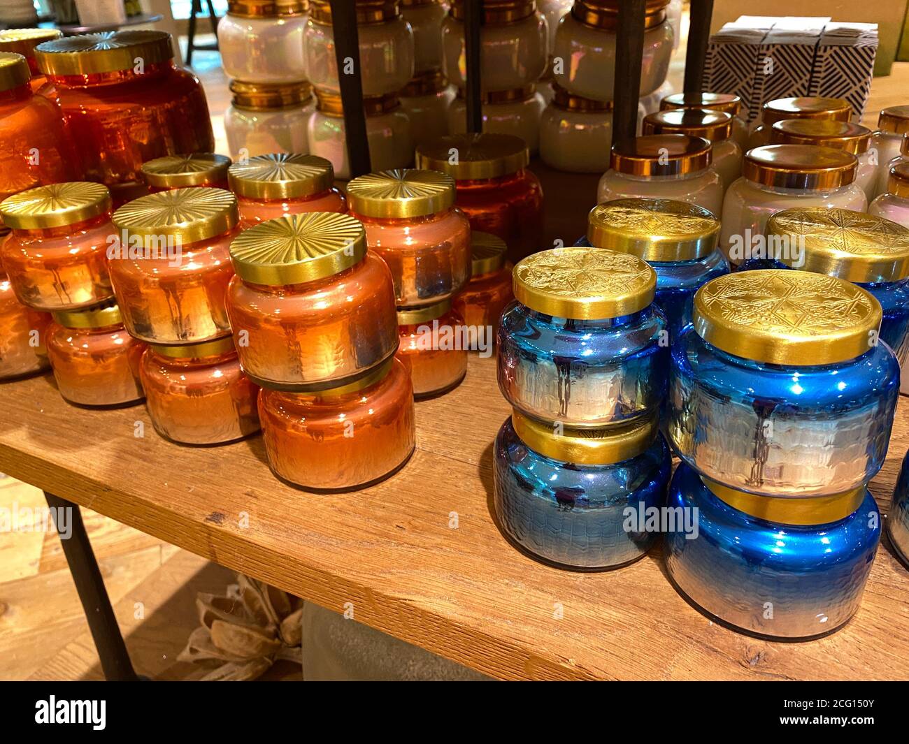 Stacks of colorful jar candles for sale at a retail store Stock Photo