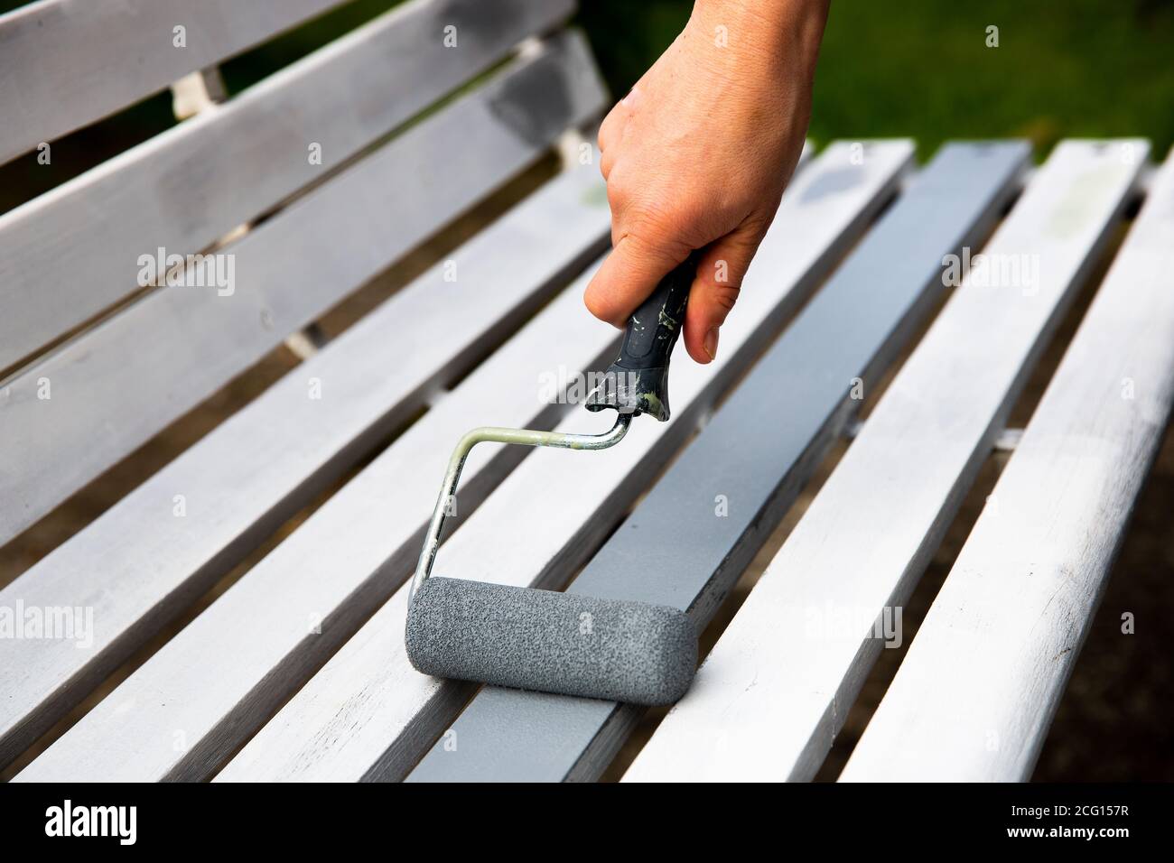 Process of hand painting white timber boards with grey paint using