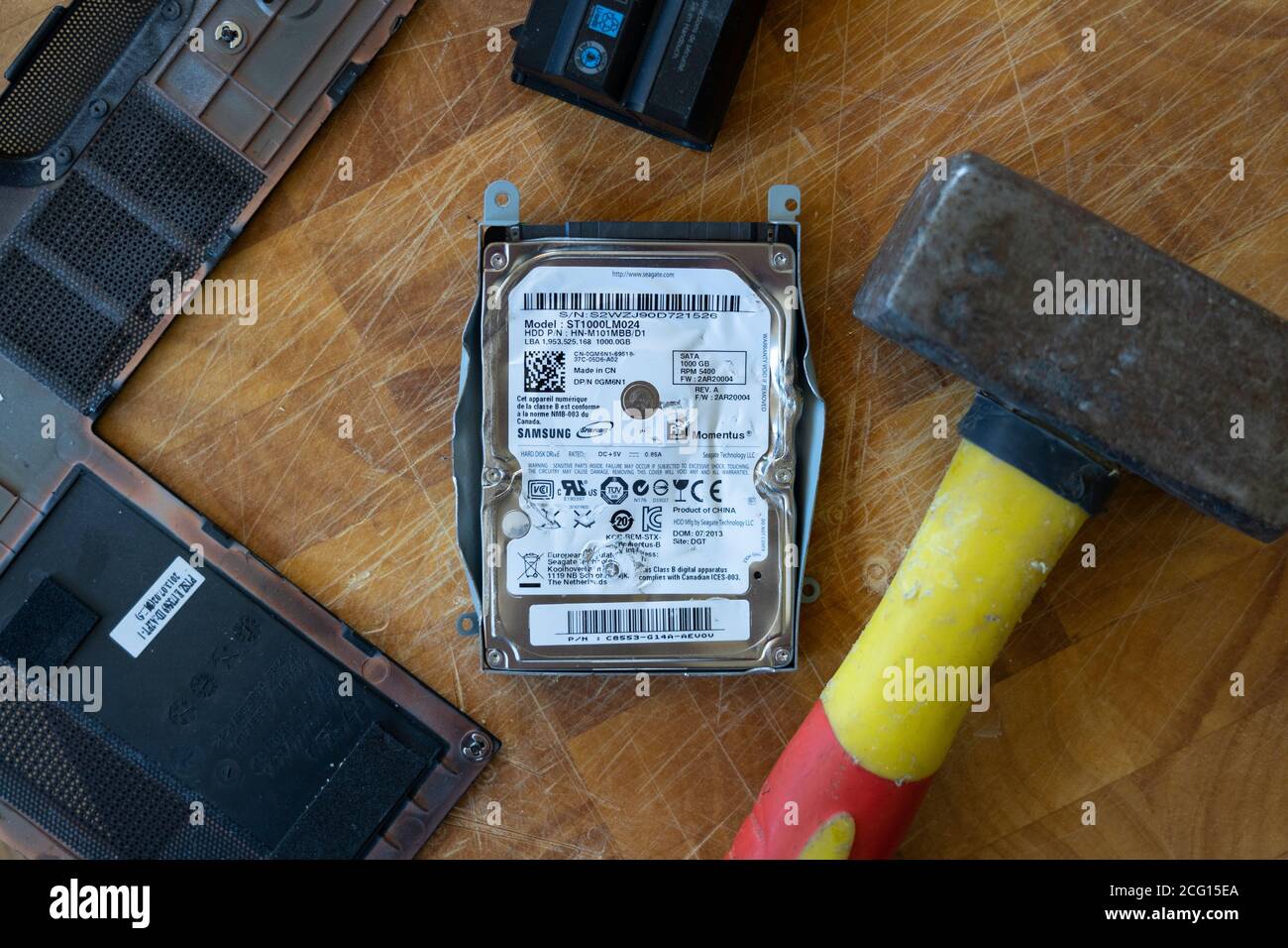 A hammer used to destroy a hard disk drive (HDD) by hammering it. Theme: data security personal data, wiping, deleting, technology, anger, frustration Stock Photo