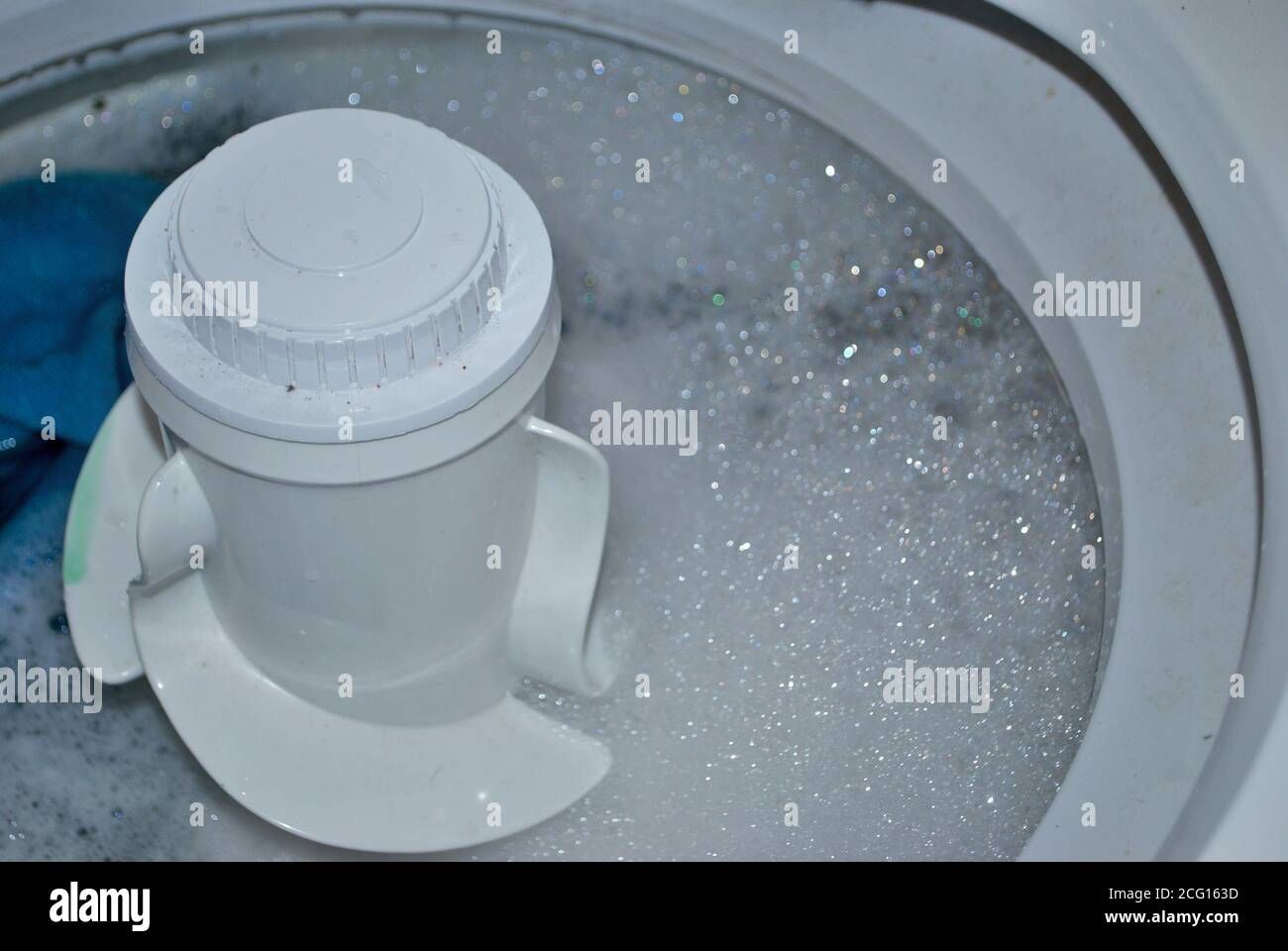 load of dirty towels in a washing machine full of water and soap