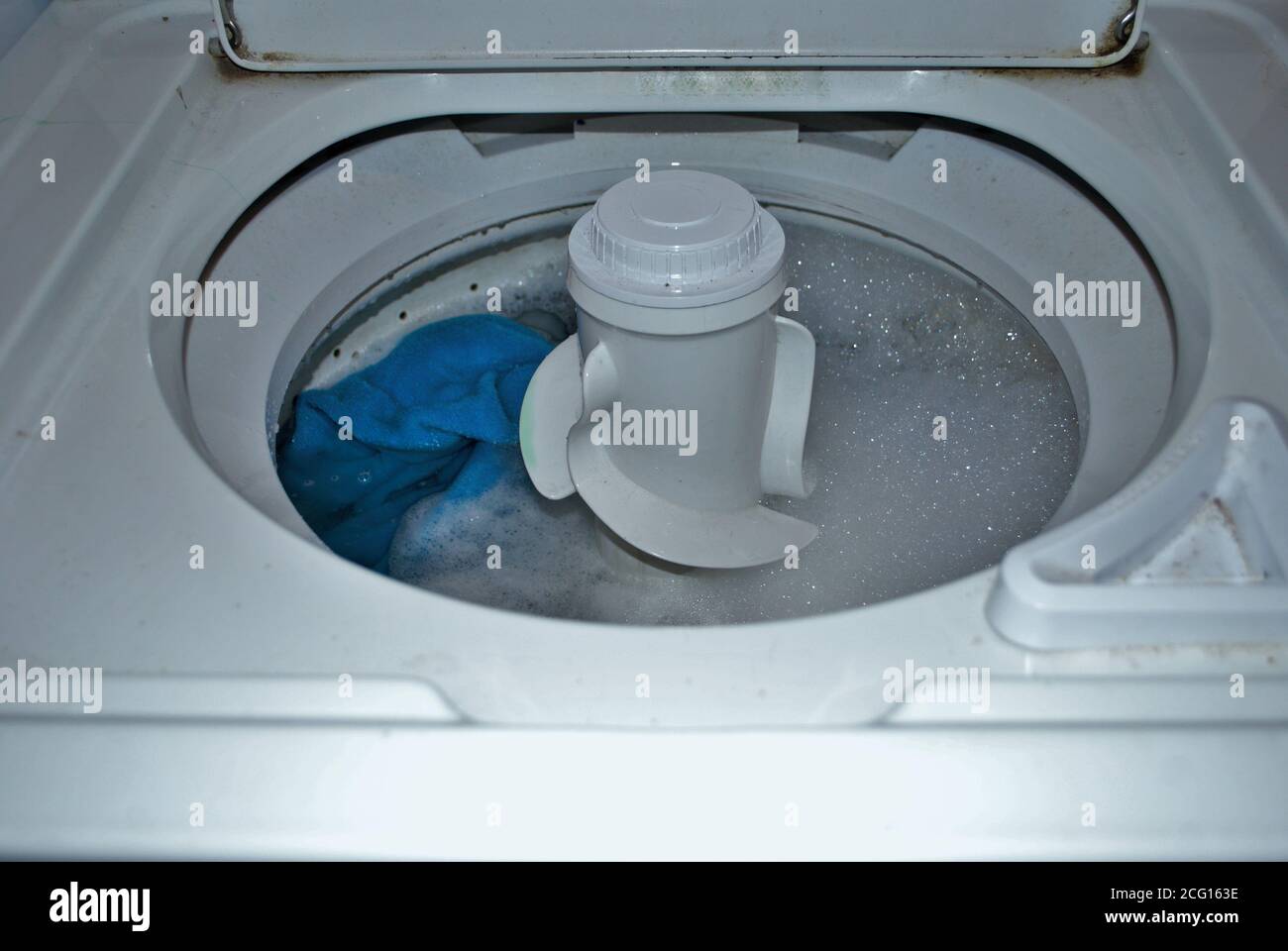 load of dirty towels in a washing machine full of water and soap