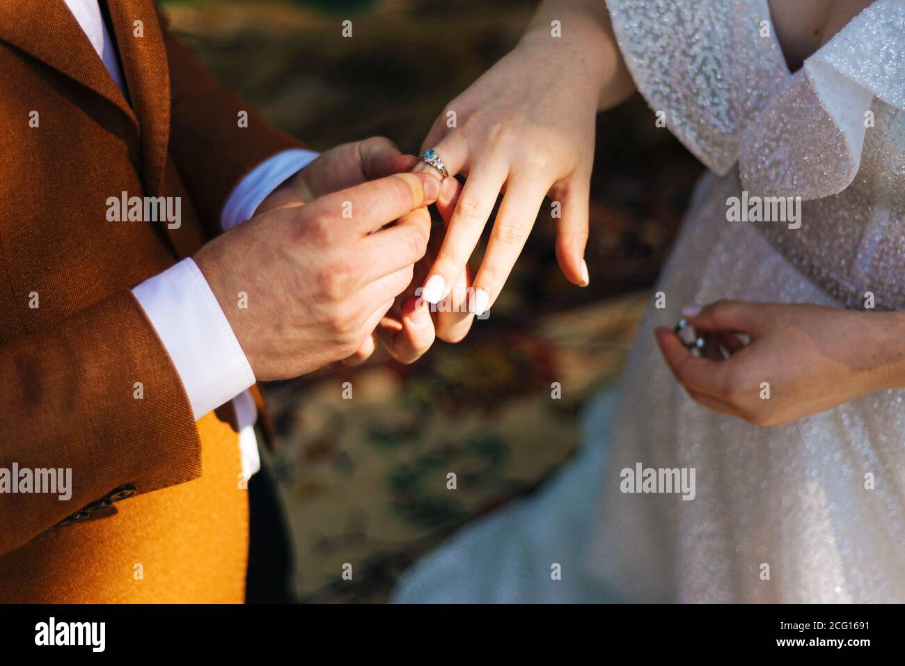Groom putting wedding ring on bride finger, wedding ceremony. Stock Photo