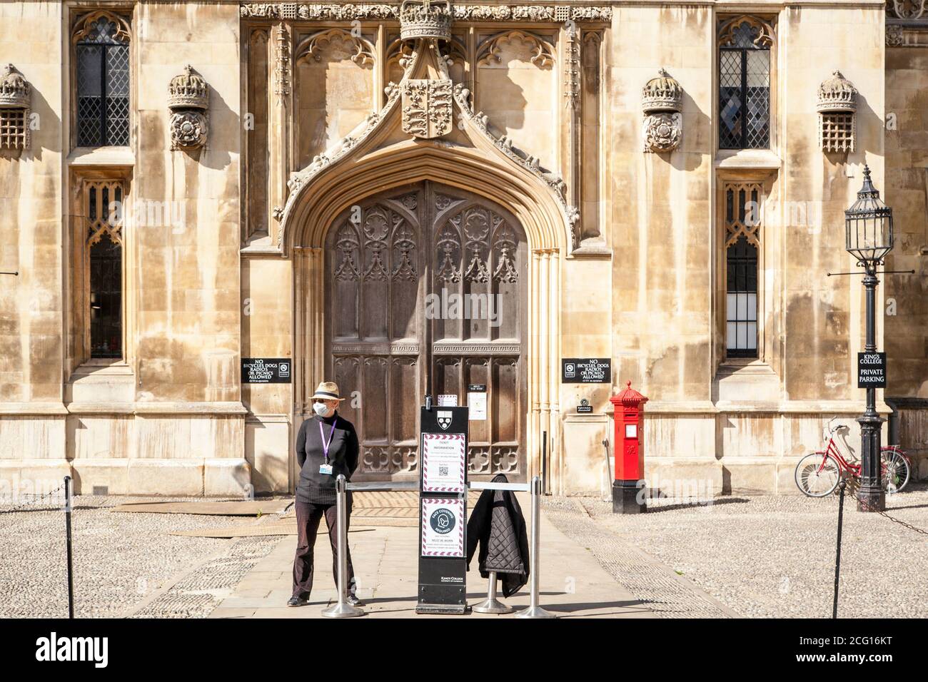 Tour guide wearing a face mask covering standing outside kings collage Cambridge waiting for customers during the covid pandemic of 2020 Stock Photo