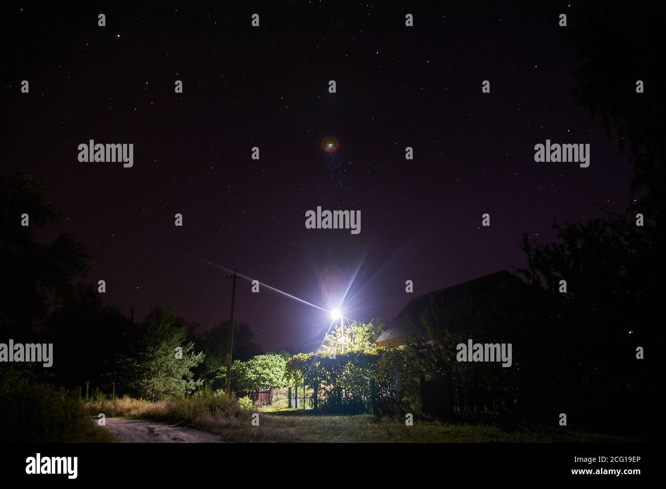 a house in the village under the starry sky lit by a lantern, night ...