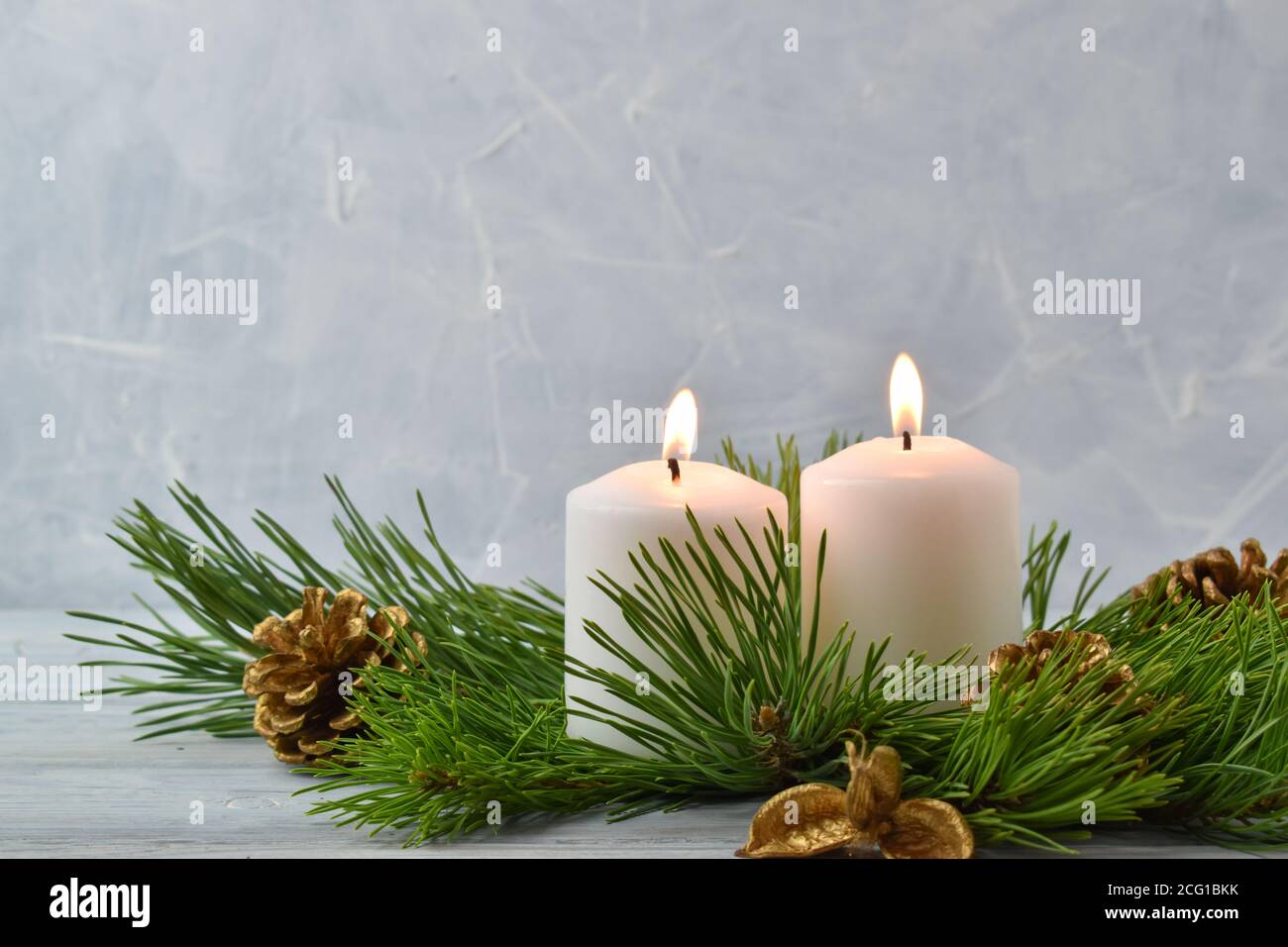 Christmas composition. Two candles and pine branches with cones. There ...