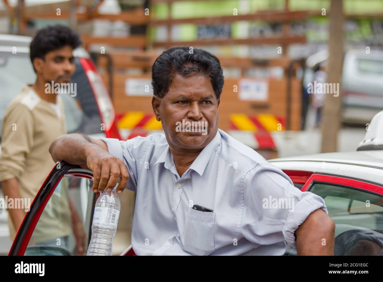 KUALA LUMPUR, MALAYSIA - DECEMBER 31, 2016 :taxi driver with water bottle looks. Stock Photo