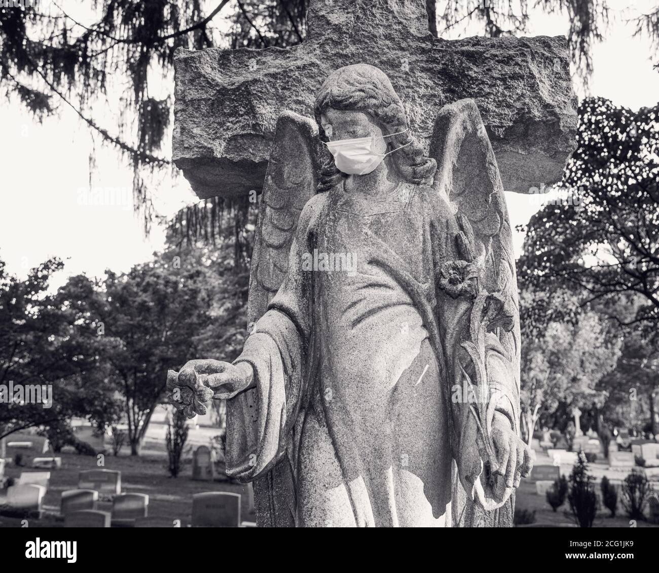 Cemetery Angel statue wearing a surgical face-mask Stock Photo