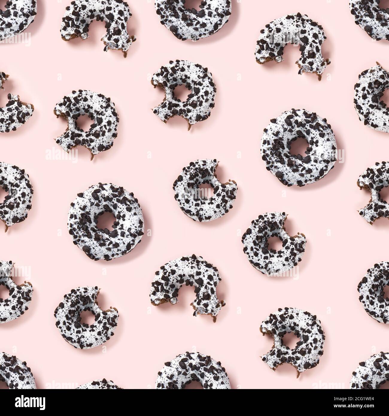 quality seamless pattern of donuts on a pink background top view. Flat lay of delicious nibbled chocolate donuts. Stock Photo