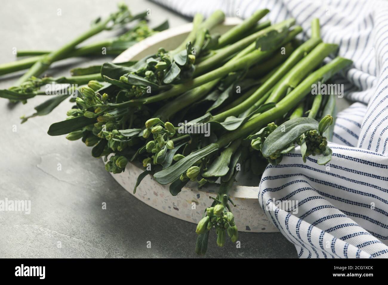 Tray with broccolini and napkin on gray background Stock Photo