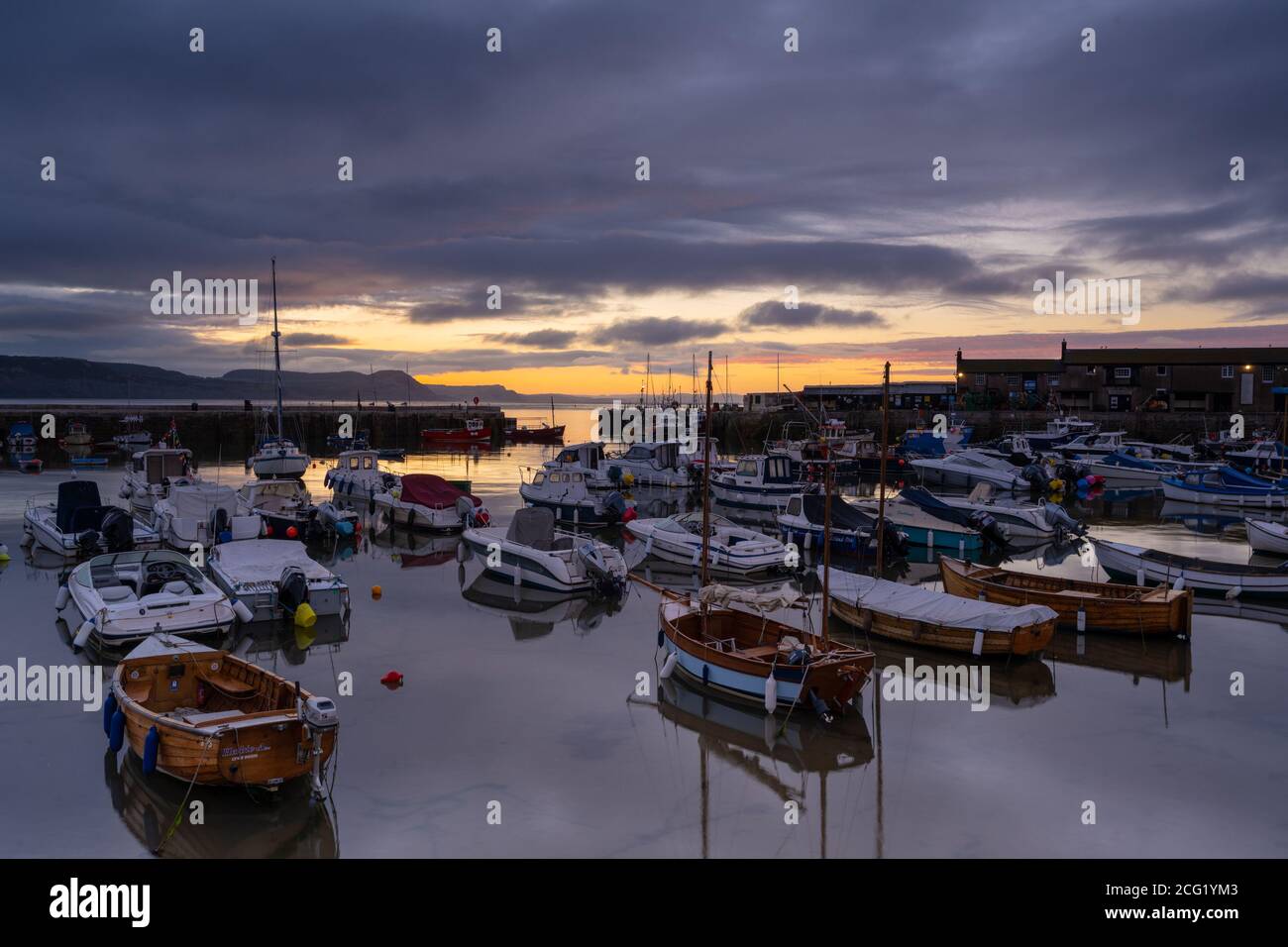 Lyme Regis, Dorset, UK. 9th Sep, 2020. UK Weather: The sun breaks through cloud over the Cobb at Lyme Regis after a rather moody start to the day. Credit: Celia McMahon/Alamy Live News Stock Photo