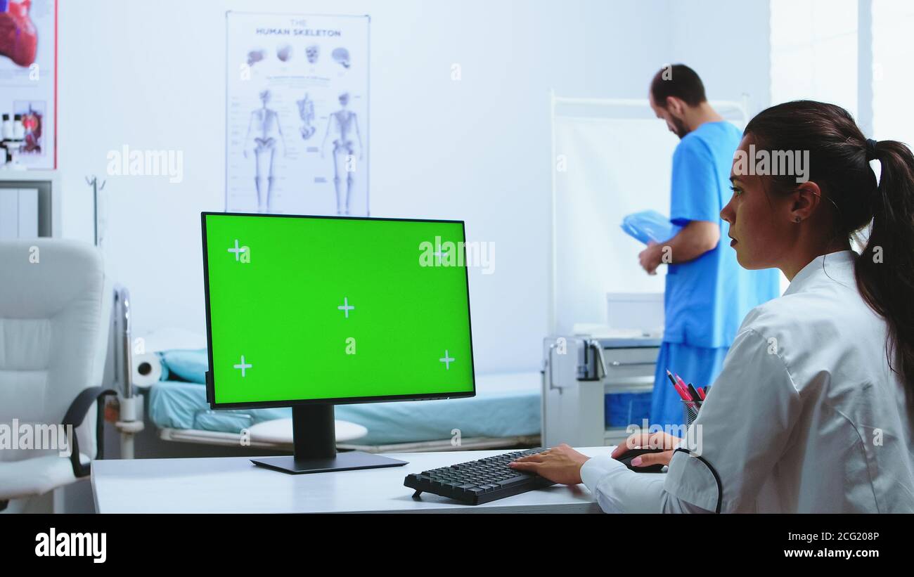 Bác sĩ đang sử dụng máy tính với màn hình xanh để kiểm tra tình trạng sức khỏe của bệnh nhân tại bệnh viện. Hãy khám phá những công nghệ tiên tiến và hiện đại nhất để đưa ra chẩn đoán và chữa trị các bệnh tật. Xem hình ảnh để tìm hiểu cách bác sĩ sử dụng máy tính với màn hình xanh để giúp bệnh nhân của mình.