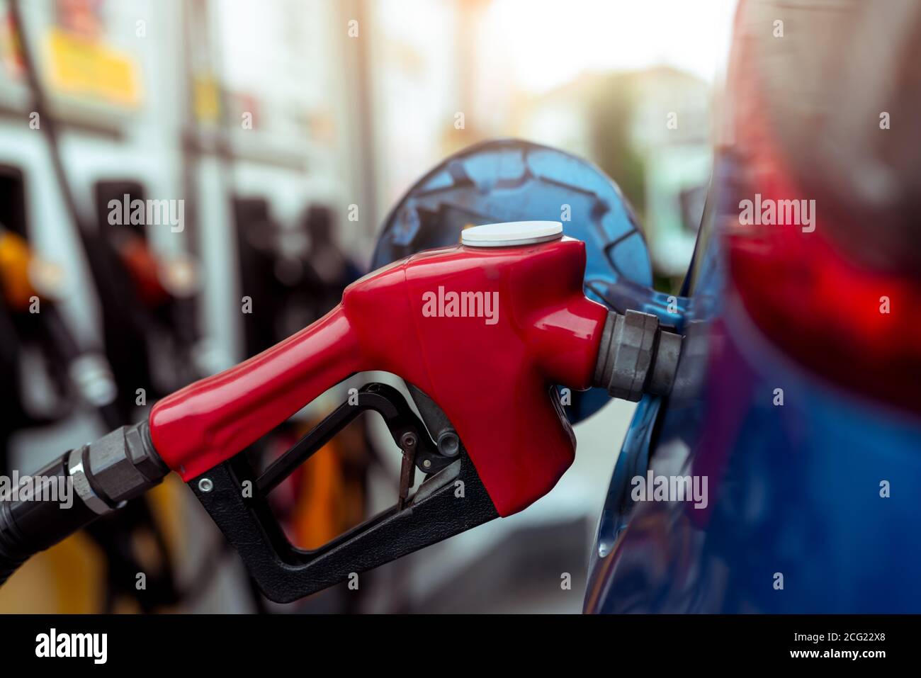 Car fueling at gas station. Refuel fill up with petrol gasoline. Petrol pump filling fuel nozzle in fuel tank of car at gas station. Petrol industry. Stock Photo