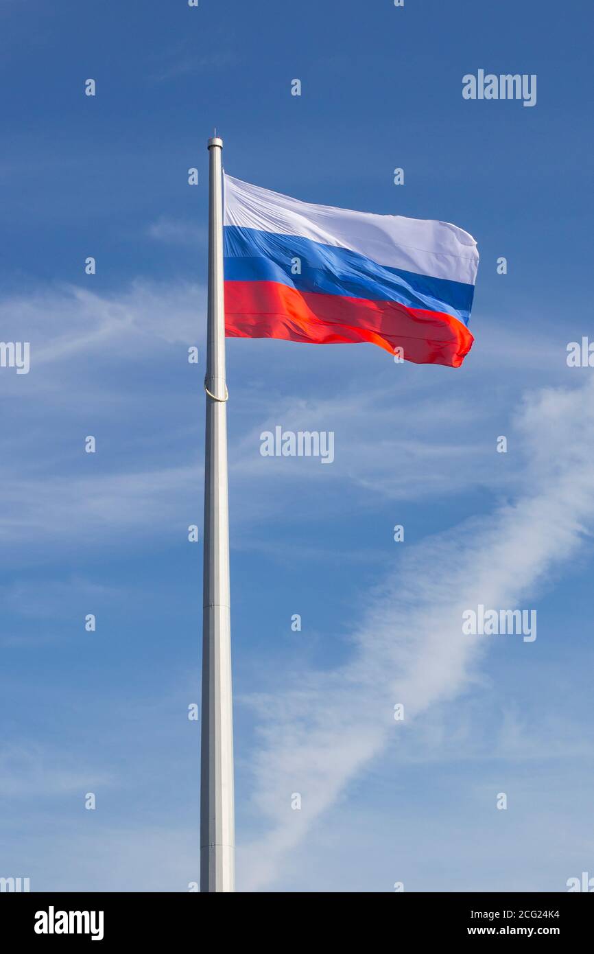 flagpole with waving Russian flag against the blue sky Stock Photo
