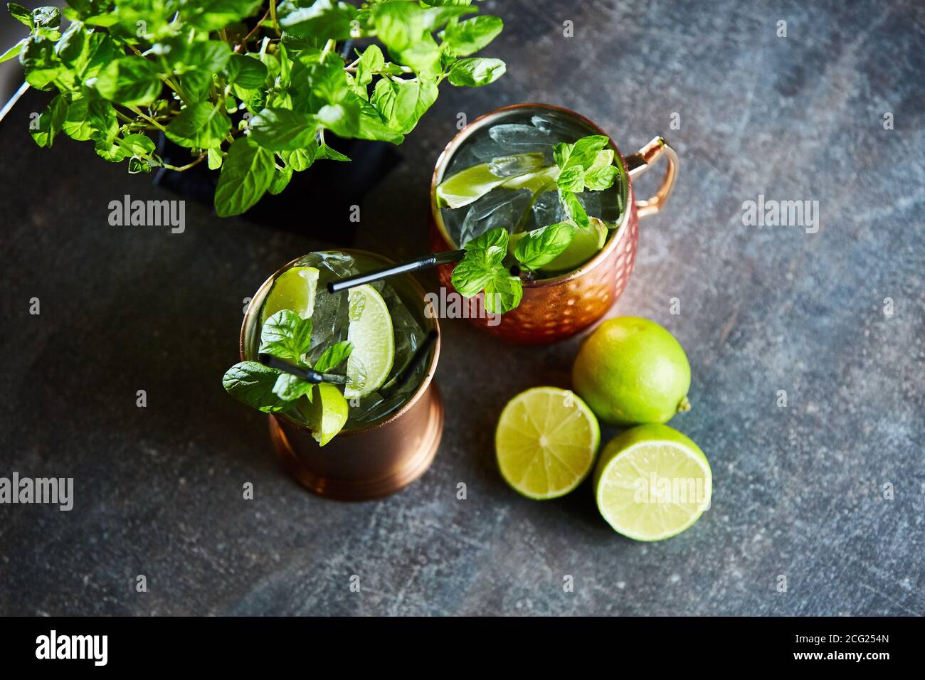 Cuba Libre, Rum and Cola drink with lime in copper mugs on a bar Stock