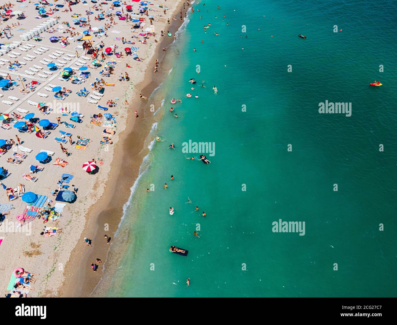 Aerial View Of People And Colorful Umbrellas On Ocean Seaside Beach In