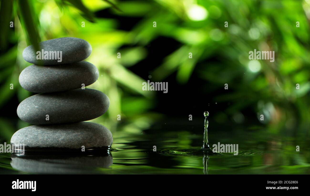 Tranquil water surface with black lava stones, spa and wellness concept. Stock Photo