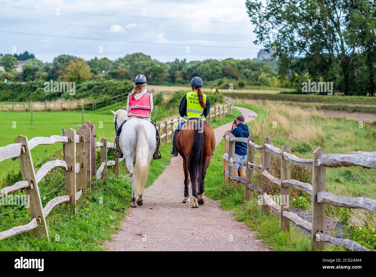 Girls with high visibility jackets on riding horses Stock Photo