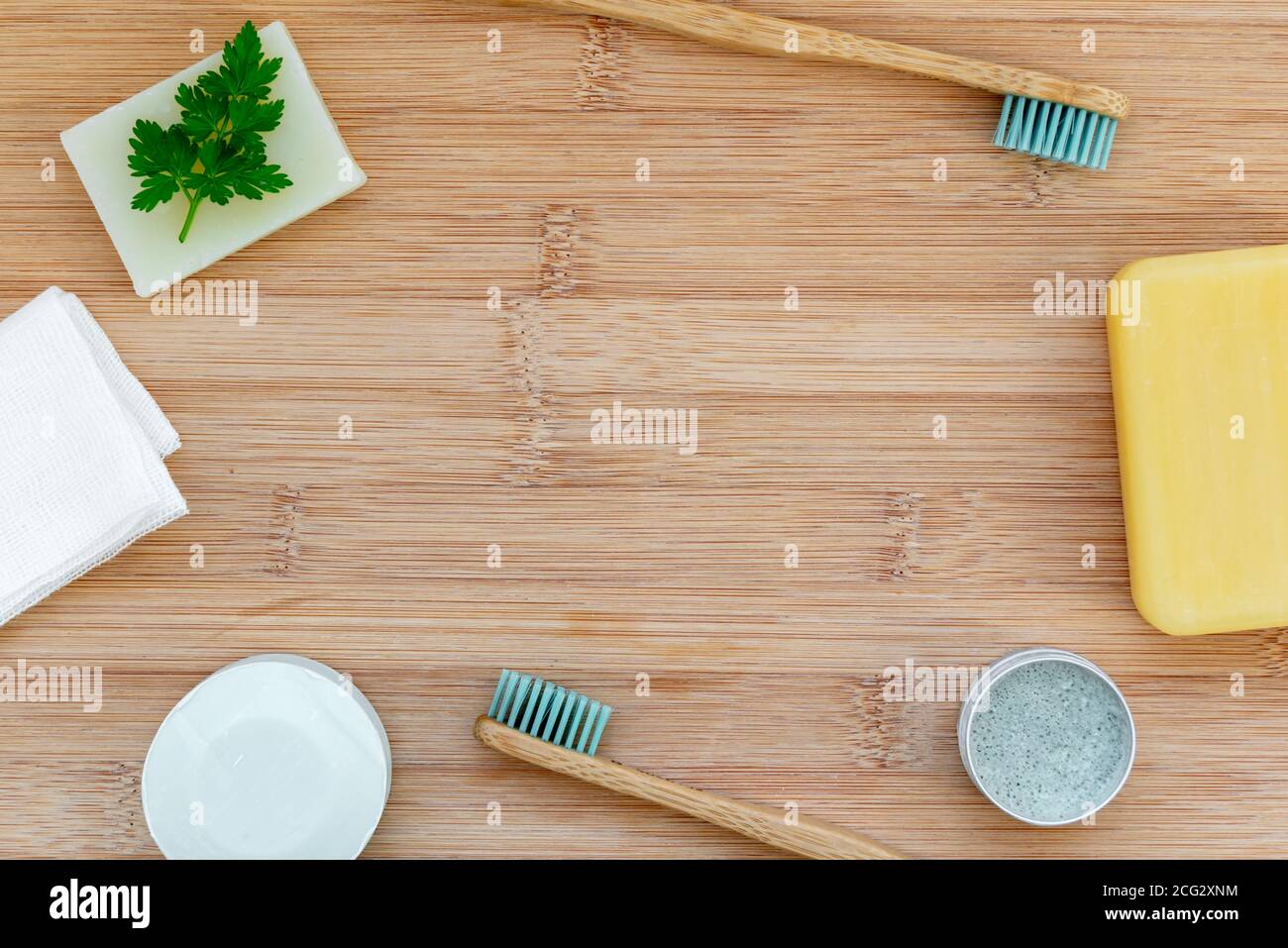 Zero waste bathroom backdrop with copy space. Bamboo toothbrushes, solid toothpaste, solid shampoo and soap on wood background. Plastic free, environm Stock Photo