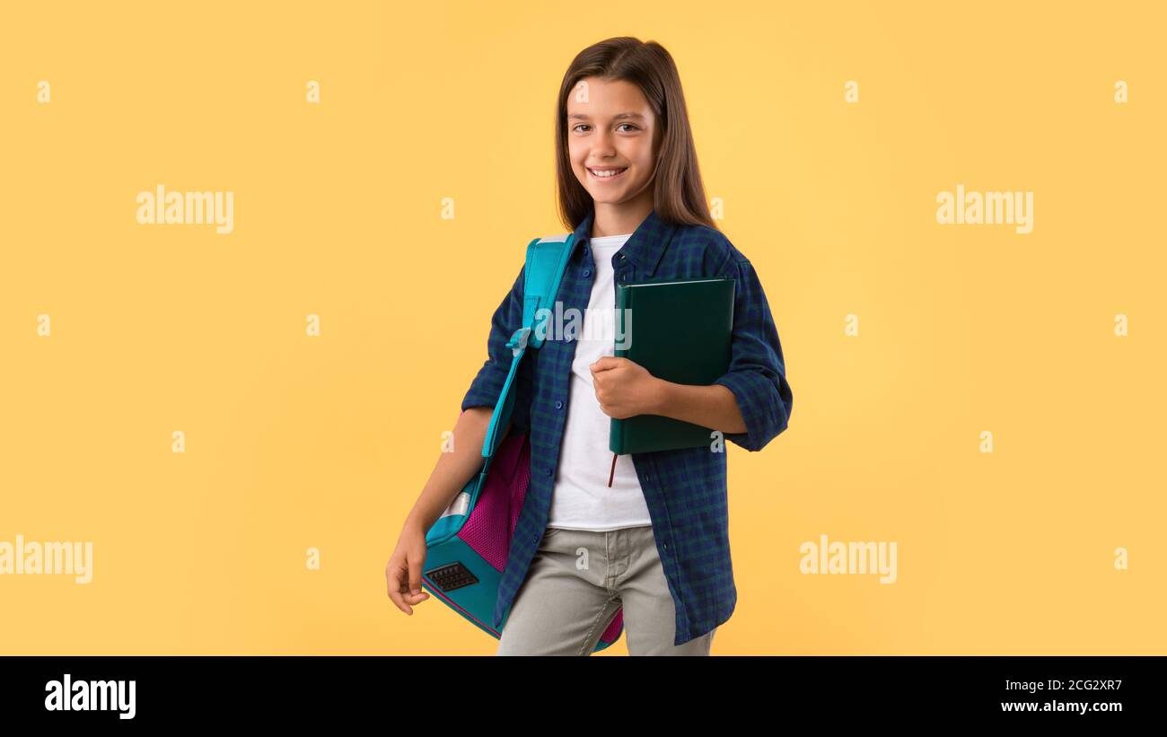 Smiling girl holding textbook at studio background Stock Photo - Alamy
