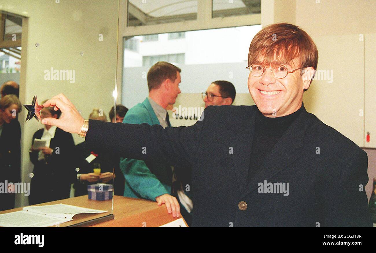 PAP 6 29.11.94. LONDON. Elton John sticks an inscribed star, which was presented to him, on a glass wall during the officially opening of the first phase of The Crusaid Centre - The HIV Reasearch and Information Exchange in London today (Tuesday). The pop star's charity (the Elton John AIDS Foundation), part funded this phase of the centre. PA News, Tony Harris. See PA story HEALTH Elton . /PJ. Stock Photo