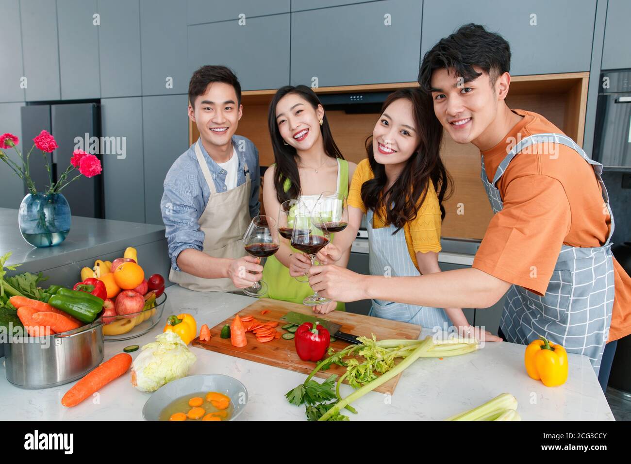 Happy young cook while drinking red wine Stock Photo
