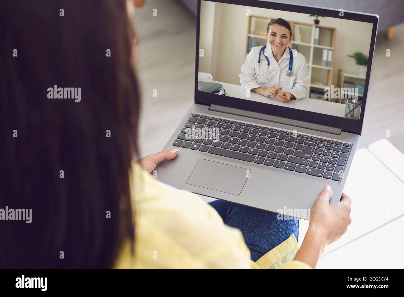 Online doctor consultation. Woman is at home, uses online doctor service. Stock Photo