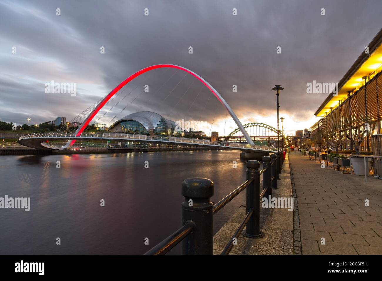 The Gateshead Millennium Bridge spanning the River Tyne captured at dusk from Newcastle quayside looking up the River Tyne. Stock Photo