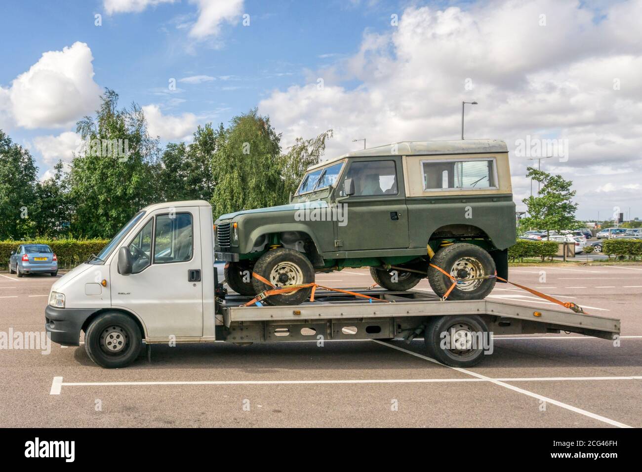 Land Rover Defender on back of Citroen Relay recovery truck.  NB: Lamp post removed from background. Stock Photo