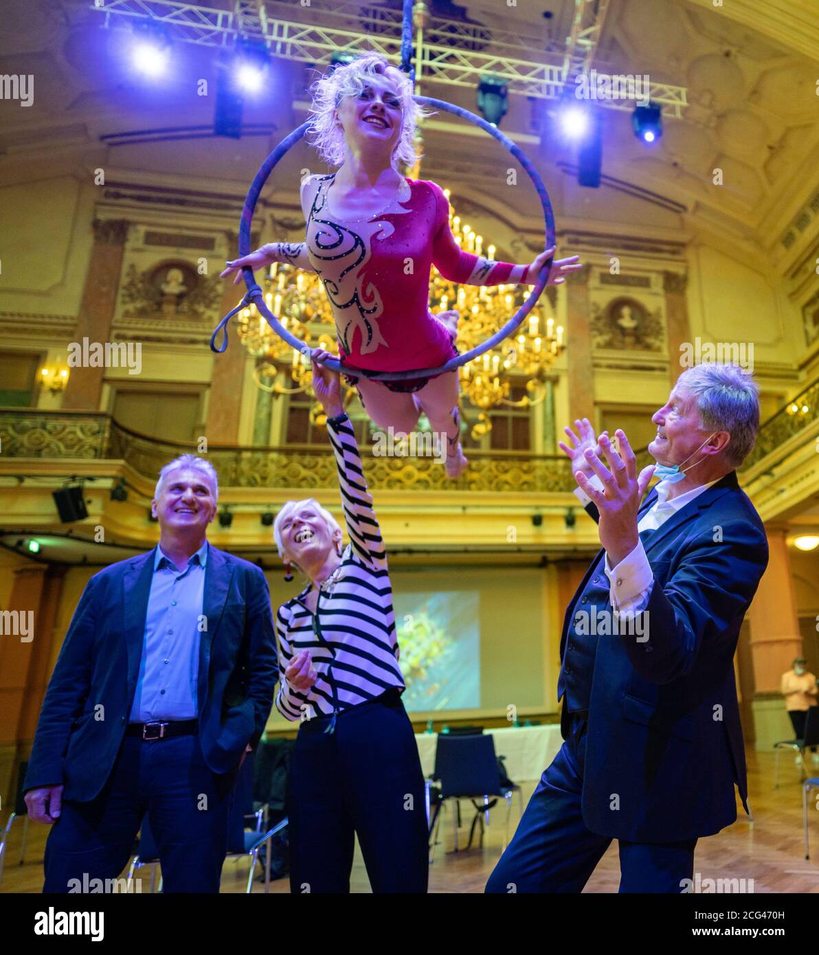 Frankfurt, Germany. 9th Sep 2020.  The artist Alyona Pavlova demonstrates her skills in the Gesellschaftshaus of the Frankfurt Palmengarten in a ring hanging from the ceiling, while beneath it (L-R) Robert Mangold, managing director of the Gesellschaftshaus, and the founders and directors of the Tigerpalast Theater, Margareta Dillinger and Johnny Klinke, stand. Credit: dpa picture alliance/Alamy Live News Stock Photo