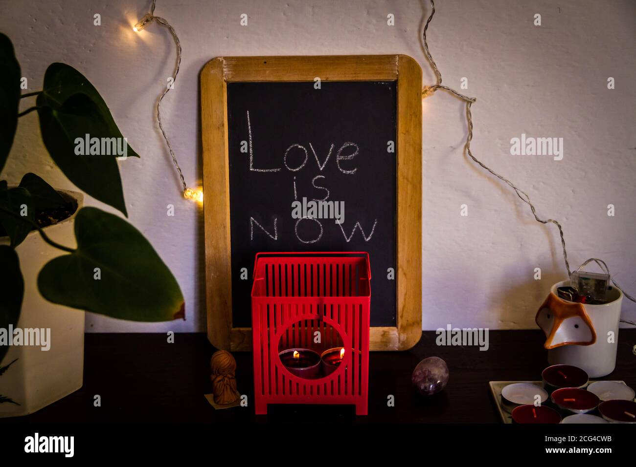 Cozy home design with blackboard written 'Love is now' Stock Photo