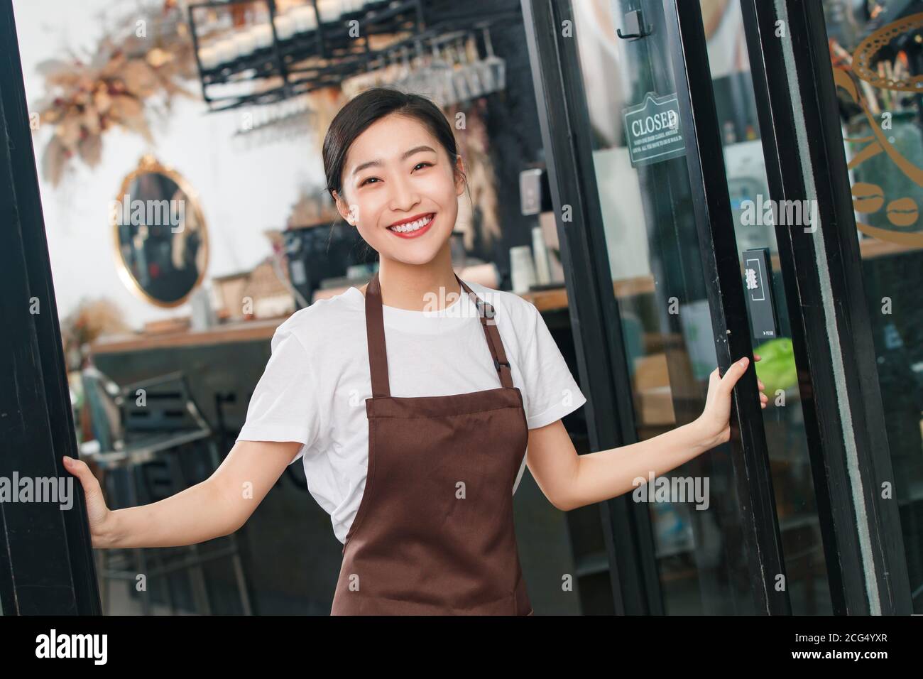 Standing at the door of the cafe waitress Stock Photo