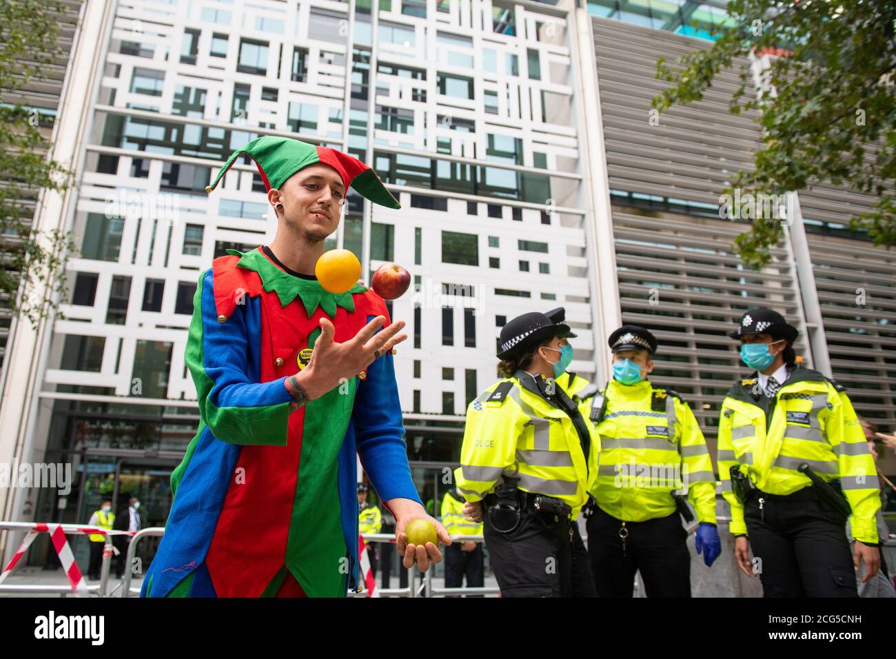 A costumed Animal Rebellion protestor juggles outside the Department for Food, Environment and Rural Affairs, in Westminster, London. Stock Photo