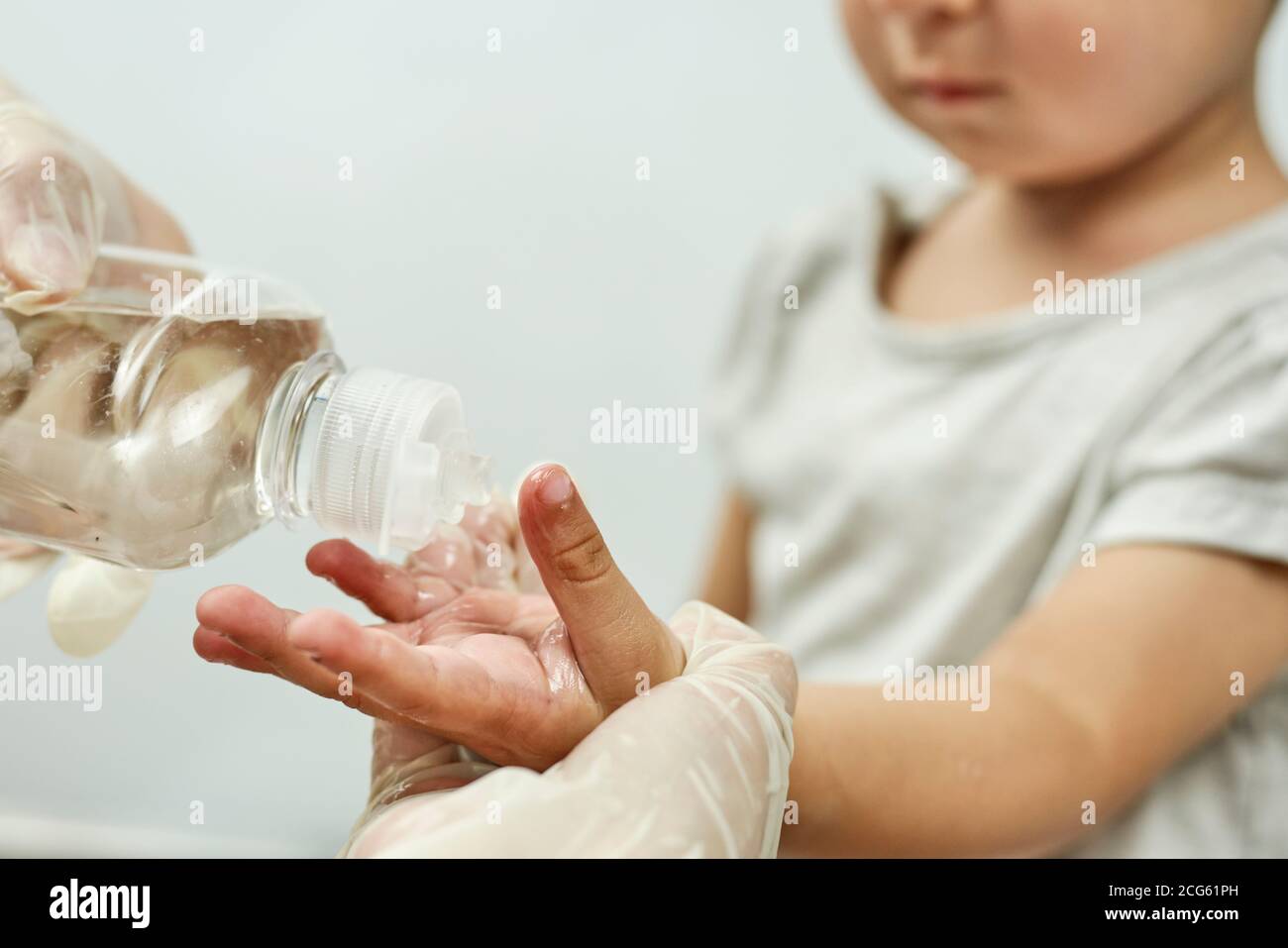 Doctor putting hand sanitizer to baby hands. Teaching a baby boy hand
