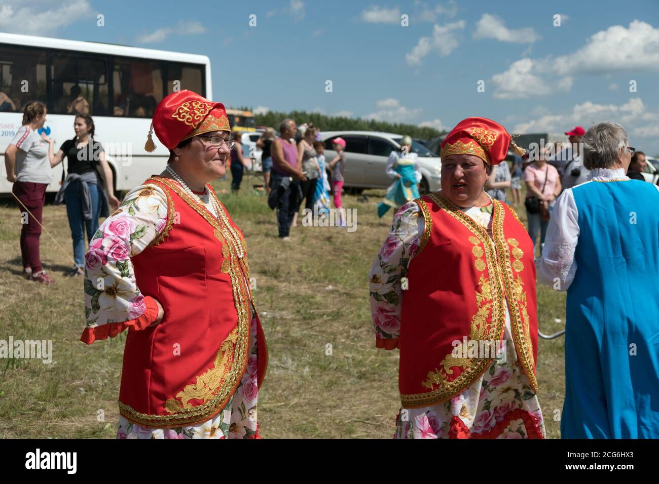 Two women in national Tatar folk costume  stands among people during the ethnic festival Karatag on the shore of a Large lake. Stock Photo