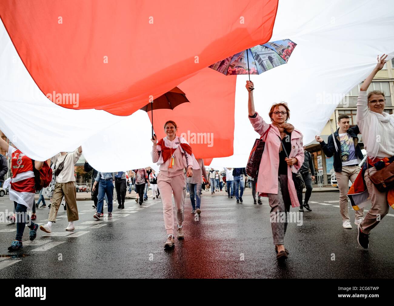 Minsk, Belarus - August 23, 2020: Belarusian people carry giant historical flag of Belarus. They participate in peaceful protest after presidential el Stock Photo