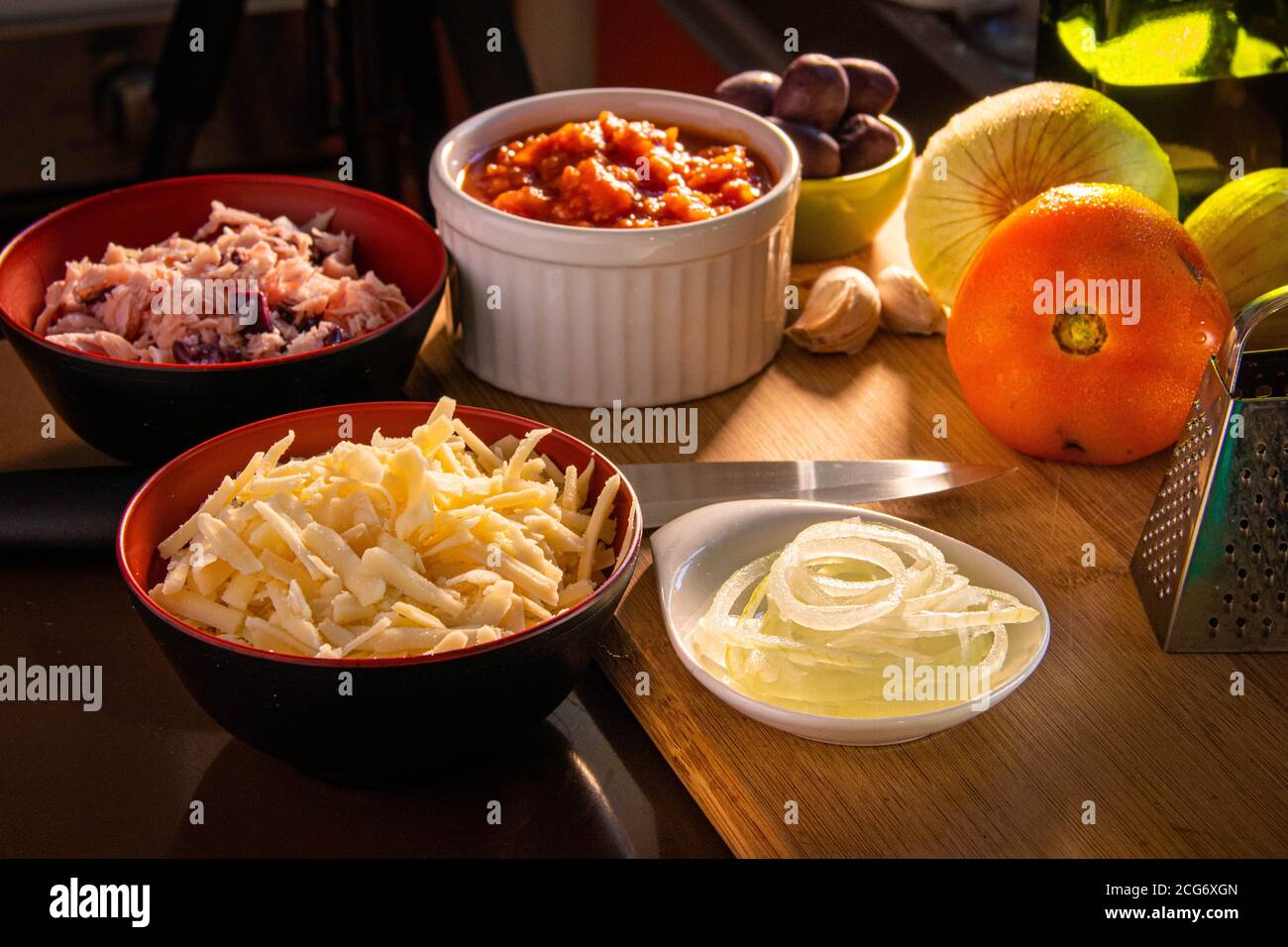 Bowls of pizza toppings in a kitchen Stock Photo