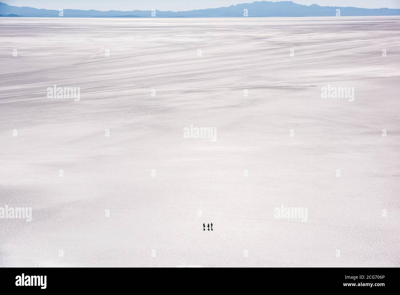 Aerial view of three tourists walking across the Uyuni Salt flat, Altiplano, Bolivia Stock Photo