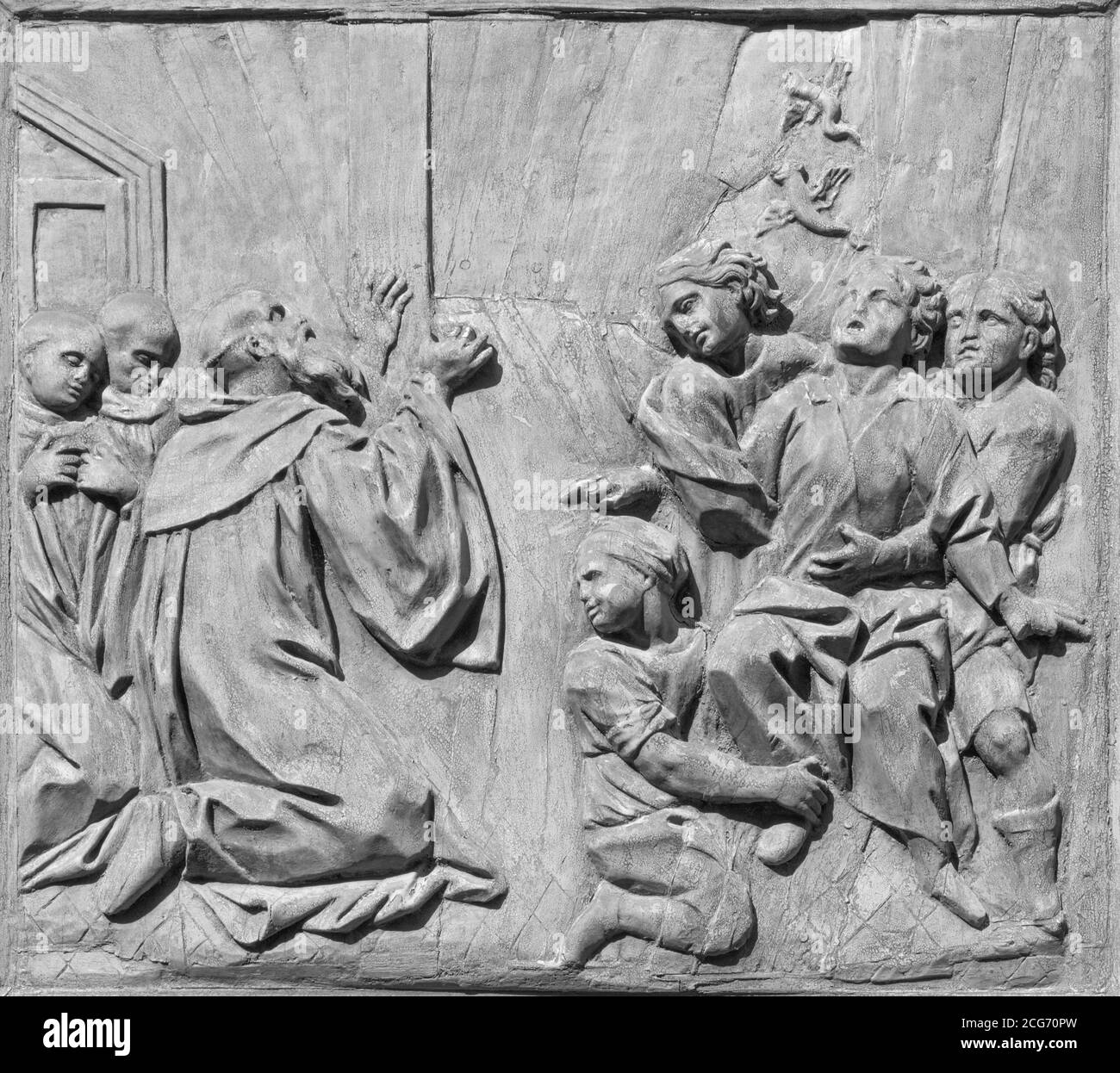 CATANIA, ITALY - APRIL 7, 2018: The baroque carved relief from live of St. Benedict (healing of a boy of leprosy) on the gate of church . Stock Photo