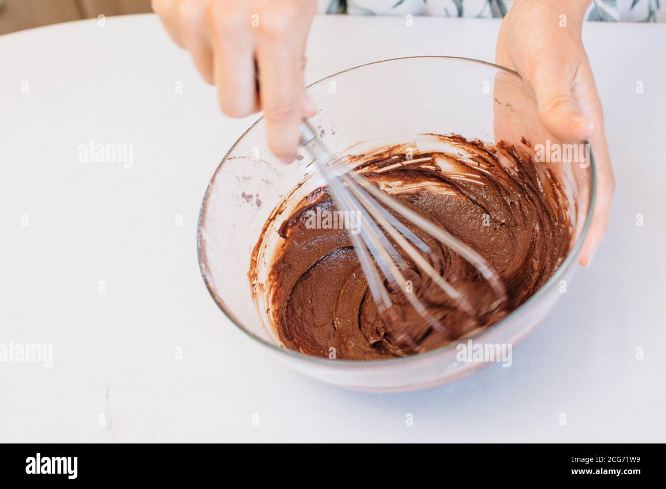 Woman standing in kitchen whisking cake batter Stock Photo