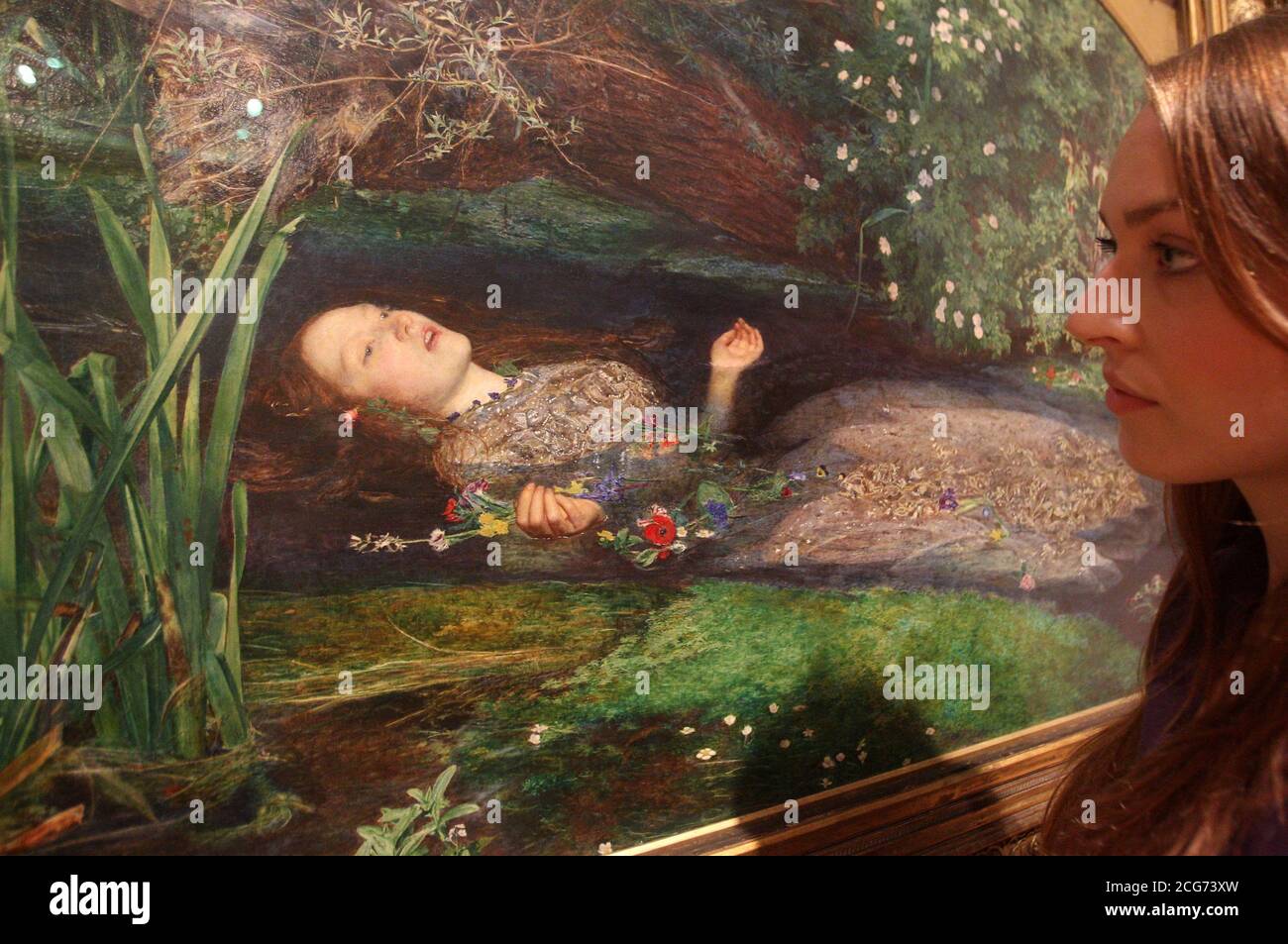 A gallery worker looks at Ophelia 1851-2 by John Everett Millais, the most famous work in the Pre-Raphaelites: Victorian Avante-Garde autumn show at the Tate Britain, London. Stock Photo