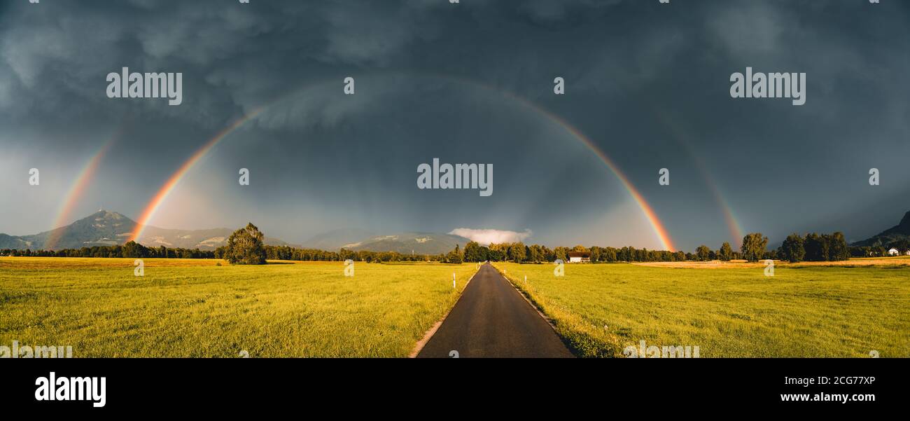 Double rainbow over a road through rural landscape, Salzburg, Austria Stock Photo